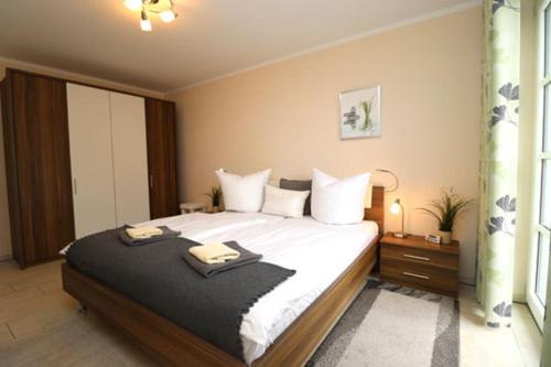 a bedroom with a large bed with two towels on it at Residenz am Hafen Boddensuite in Ahrenshoop