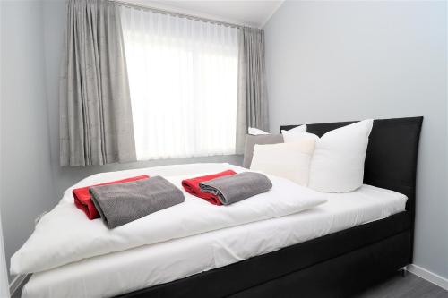 a bedroom with a bed with two towels on it at Meerquartier App 08 in Neuhaus