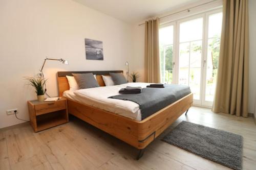 um quarto com uma cama grande e uma janela grande em Bickbeeren Schweiz Villa Catrina, App 05 em Dierhagen