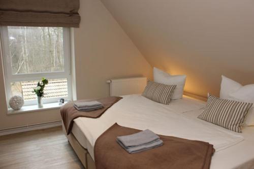 a bedroom with two beds and a window at Strandvilla Birkenallee Haus Sommerlicht in Neuhaus