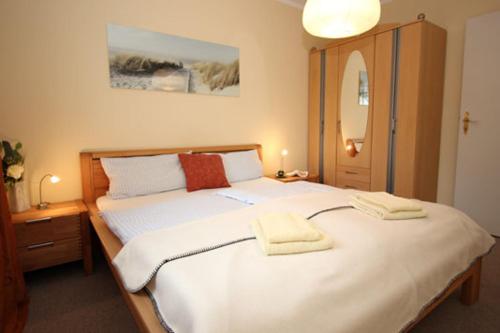 une chambre avec un grand lit avec deux serviettes dessus dans l'établissement Mühlenweg, App 01, à Wieck