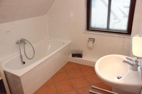 Ferienhäuser Ferienhaus Xenia في ويك: حمام مع حوض استحمام ومغسلة ومرحاض