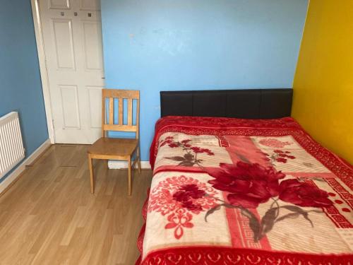 um quarto com uma cama com um cobertor vermelho e uma cadeira em The Woodfield Hotel em Blackpool