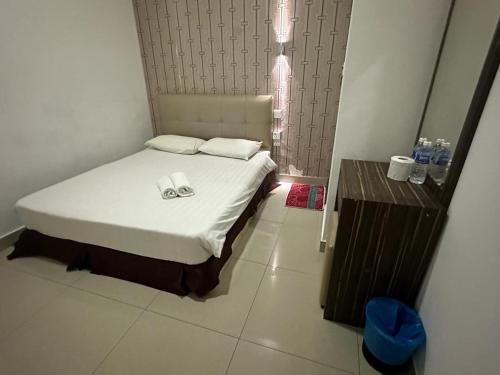 a small bedroom with a bed and a table at One Point Hotel @ Airport (Kuching) in Kuching