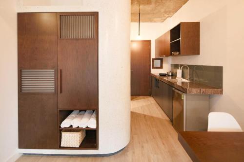 uma cozinha com armários de madeira e uma coluna em H&A Homestay - 40m, New Built, Center Location, Quiet Place, Full Facilities em Hanói