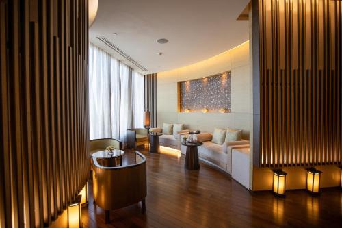 a living room with a couch and a table at The Okura Prestige Bangkok in Bangkok