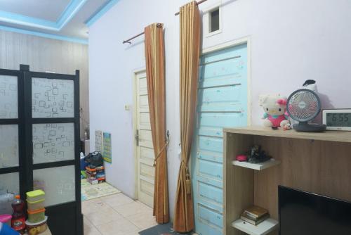的住宿－SPOT ON 92549 Wisma Ribas Syariah，一间设有蓝色抽屉的房间和一扇带风扇的门