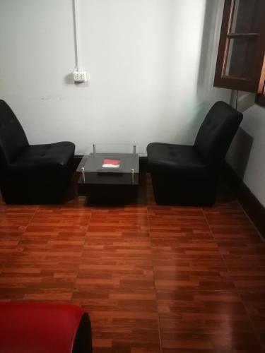 Dos sillas negras y una mesa en una habitación en una habitacion amplia para disfrutar en Lima