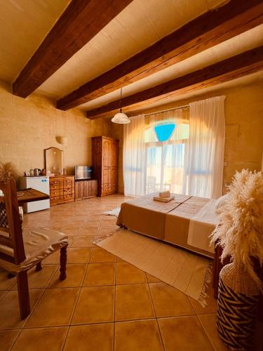 a large room with a bed and a window at Narcisa Farmhouse B&B in Nadur
