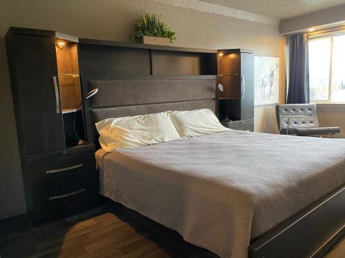a bedroom with a large bed and a chair at Travelodge by Wyndham Drummondville in Drummondville