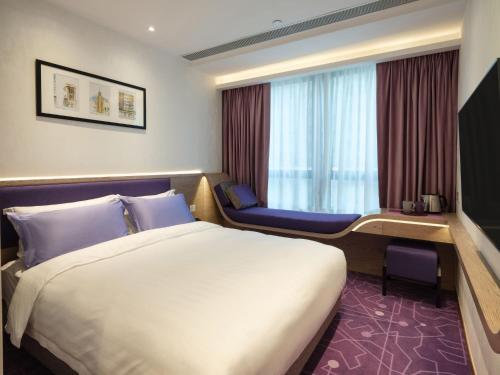 a hotel room with a bed and a chair at Hotel Purple Hong Kong in Hong Kong