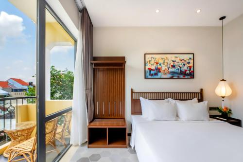 a bedroom with a bed and a balcony at Chillax Old Town Villa in Hoi An