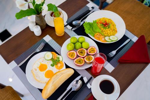 a table with plates of breakfast food on it at Chillax Old Town Villa in Hoi An