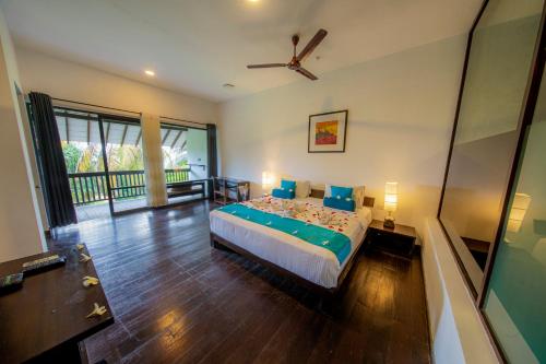 a bedroom with a bed with blue pillows at Temple Tree Resort & Spa in Bentota