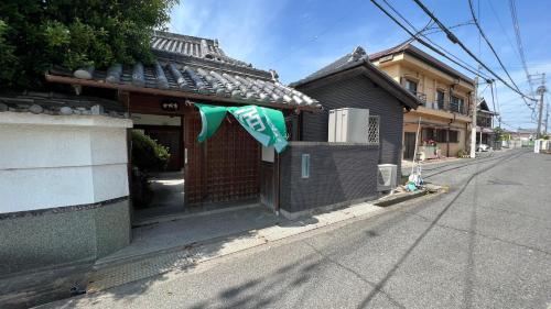 una casa con una bandera al lado de una calle en 和風庭園豪邸 en Osaka