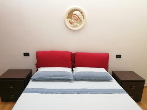 sypialnia z łóżkiem z czerwonym zagłówkiem i lustrem w obiekcie villa Grazia w mieście Rocca San Giovanni