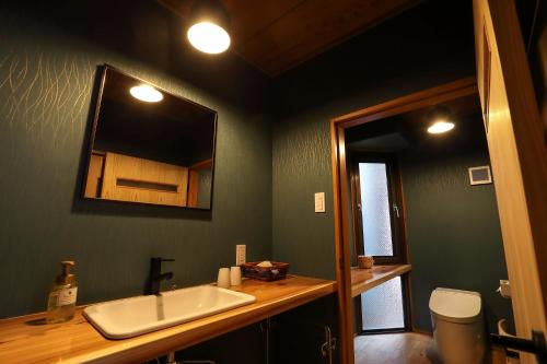 a bathroom with a sink and a mirror at Tsukasaya Ryokan in Tsuruoka