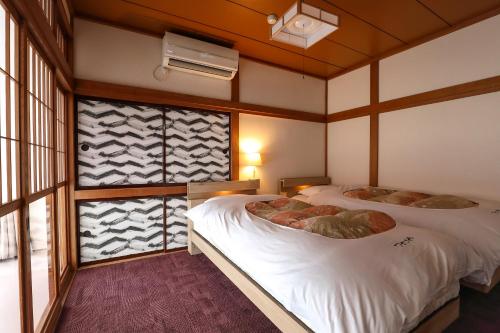 Postel nebo postele na pokoji v ubytování Tsukasaya Ryokan
