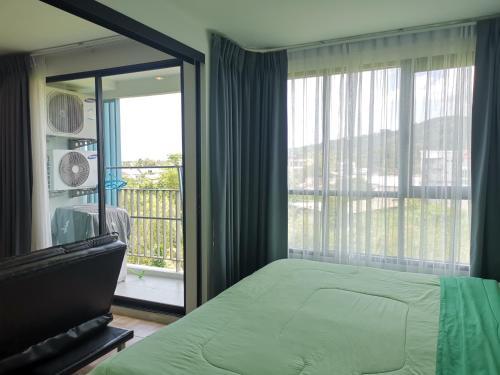5 Floor - Centrio Condominium in Phuket Town - 30 mins to beaches في فوكيت تاون: غرفة نوم بها سرير ونافذة كبيرة