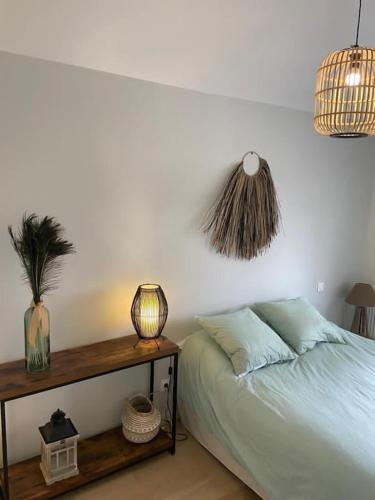 une chambre avec un lit et une table avec une lampe dans l'établissement Ville les flots bleus Proche golf Arcachon, à La Teste-de-Buch