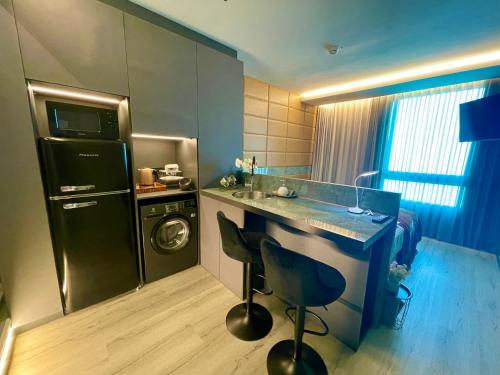 a small kitchen with a sink and a dishwasher at C Tower Premium Apartments, Panoramic Sea View in Netanya