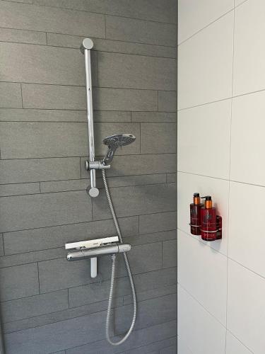 a shower with a shower head in a bathroom at Villa Victoria with sauna in Ermelo in Ermelo