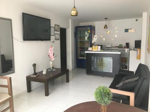 a living room with a couch and a tv on a wall at La Forêt de Café Hotel in Armenia