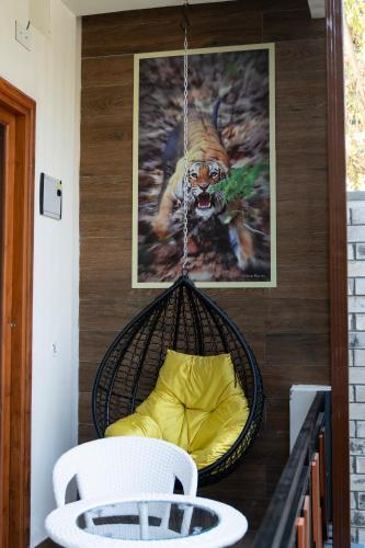 a hanging swing with a yellow cushion on a porch at Barefoot Homestays in Rāmnagar