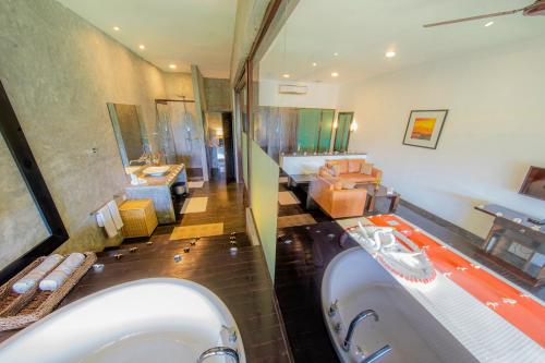 a bathroom with two sinks and a bath tub at Temple Tree Resort & Spa in Bentota