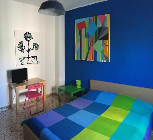 a bedroom with a bed and a desk and a painting at B&B La Galleria in Palermo