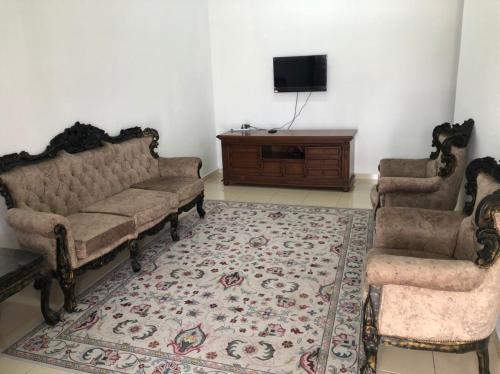 ein Wohnzimmer mit 2 Sofas und einem TV in der Unterkunft KJ HOMESTAY SUNGAI PETANI in Sungai Petani