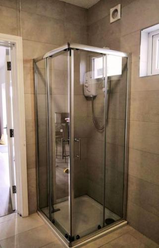 a shower with a glass door in a bathroom at Secluded Modern Guest House in Castletown Gheoghegan