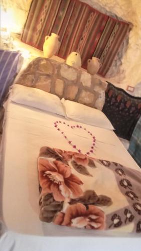 a bed with two birds sitting on top of it at Dar Fatma Toujane in Tūjān