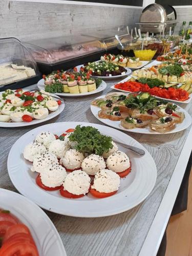 a buffet with many plates of food on a table at Great Polonia Beach & Molo in Puck