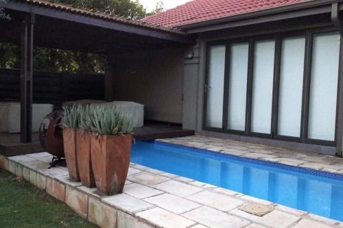 una piscina frente a una casa en Pecanwood Estate Luxury Villa 5 bedrooms with pool, en Hartbeespoort