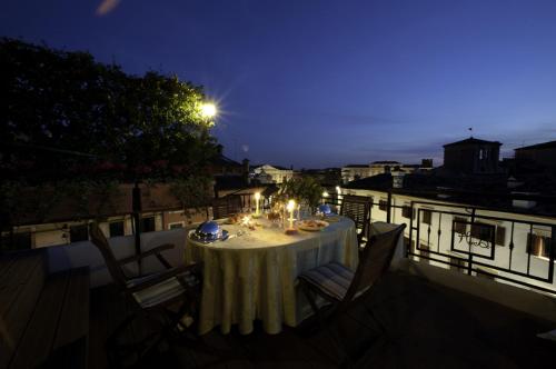 a dinner table on a balcony at night at Hotel Bologna ***S in Verona