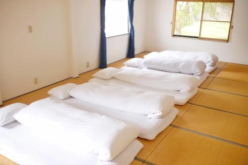 a group of white pillows lined up in a room at 湯布院我楽珍民泊Yufuin Garakuchin in Yufuin