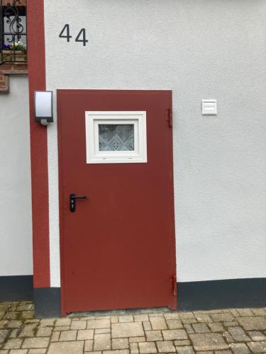 een rode deur met een raam op een gebouw bij Gemütlicher Schäferwagen im Grünen-Schäferwagen 44 in Frielendorf