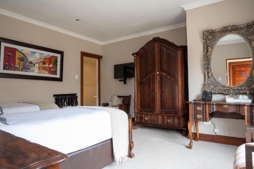 a bedroom with two beds and a large mirror at Issaquena Heights Boutique Hotel in Knysna