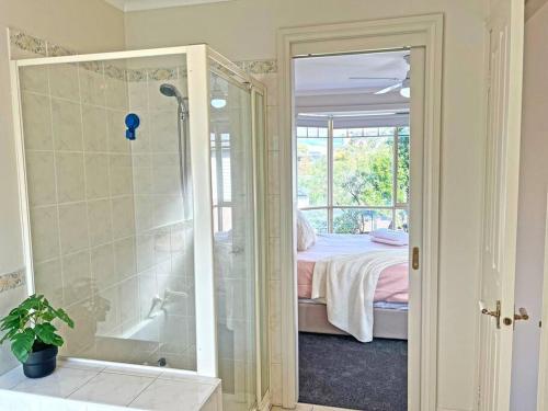 a bathroom with a shower and a bed and a tub at Charming Convenient 2BR Compact House Ringwood in Ringwood