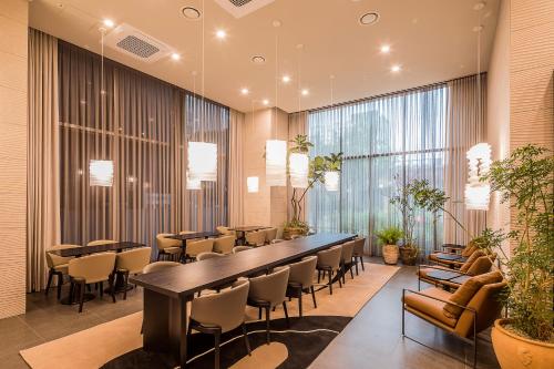 a restaurant with tables and chairs and large windows at Aank Hotel Incheon Guwol in Incheon