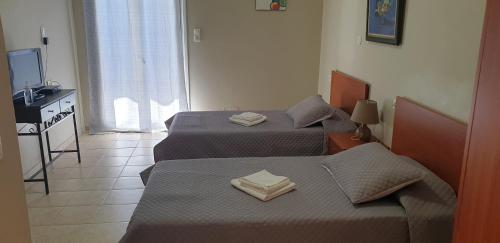 two beds in a small room with a television at Notia Gi in Kali Limenes