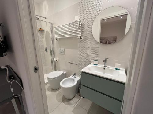 uma casa de banho com um lavatório, um WC e um espelho. em LUCE em Bolonha