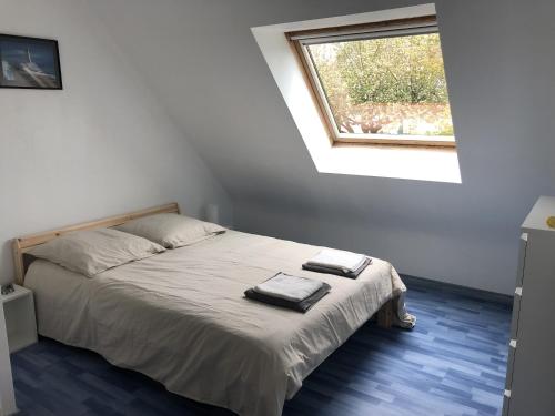 une chambre avec un lit avec deux serviettes dessus dans l'établissement Maison avec jardin au calme proche centre-ville, à Vannes