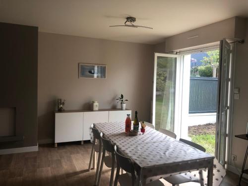 une salle à manger avec une table et des chaises et une fenêtre dans l'établissement Maison avec jardin au calme proche centre-ville, à Vannes