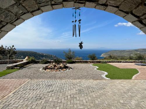 un arco con un reloj colgando sobre una hoguera en Sunset View Stone House, Areopoli Mani, en Areopoli