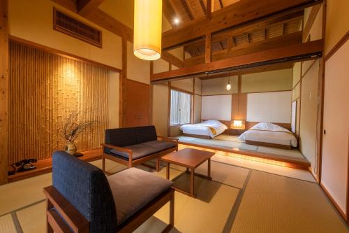 a living room with two beds and a couch at yukairouKikuya in Izu