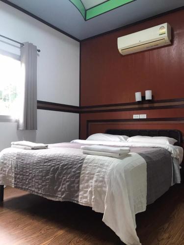 a bedroom with a bed with white sheets and a window at Fine Times Resort in Ko Chang