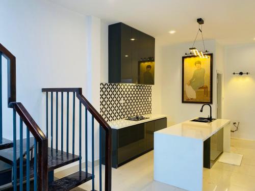 a bathroom with a counter and a staircase with a sink at Mia's House Hue in Thôn Kim Long (1)