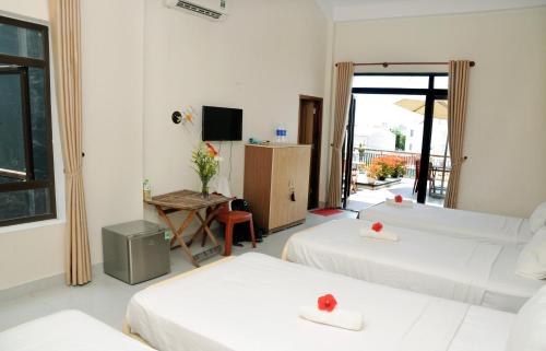 a hotel room with two beds and a television at Melody Boutique Villa Hoi An in Hoi An